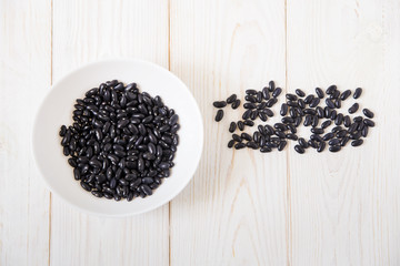 black kidney beans in the white plate.wooden background.top view