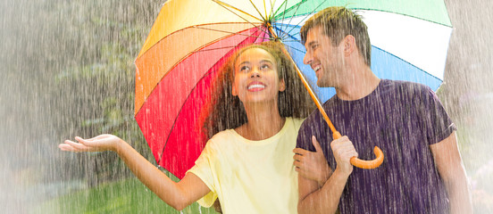 Multicultural couple under rainbow umbrella