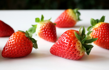 Food background .Closeup on a freshly organic red ripe strawberries lying on a white background.Summer ripe berries.Delicious fruit. Space for text in corner .Blurred background.