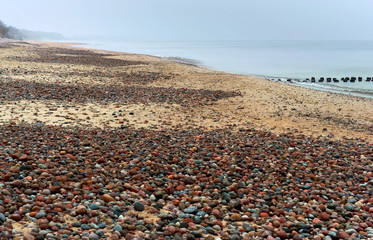 Rocks on the seashore. The sandy shore of the sea. Waves on the Baltic Sea.