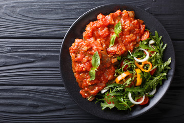 steak carne alla pizzaiola and fresh vegetable salad close-up on a plate. horizontal top view