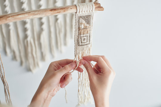 Macrame, women's hobby. Hands close up. Knitted fabric