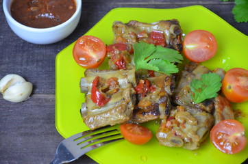 lamb grill with herbs, tomatoes and sauce on a green plate, fork