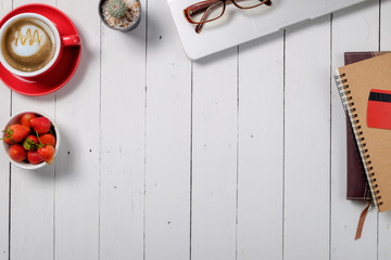 Office wood white desk table with laptop, supplies,notebook, card,eyeglasses and coffee cup. Top view workspace and copy space