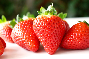 Food background .Closeup on a freshly organic red ripe strawberries lying on a white background.Summer ripe berries.Delicious fruit. Space for text in corner .Blurred background.