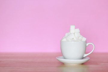 Unhealthy food concept, White sugar in white cup on pink background