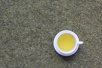 Top view of Tea cup with tea bag on dried tea leaves background