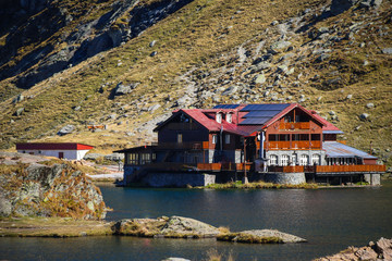 Autumn landscape with cabin and Fagaras mountains in the background at the Balea Lake, in Sibiu...