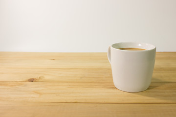 Coffee cup on wooden table with white background.