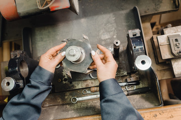 a working girl is inserting cutting mill in machine