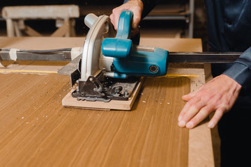 The worker saws the wood