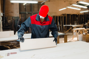 the worker grinds the door parts