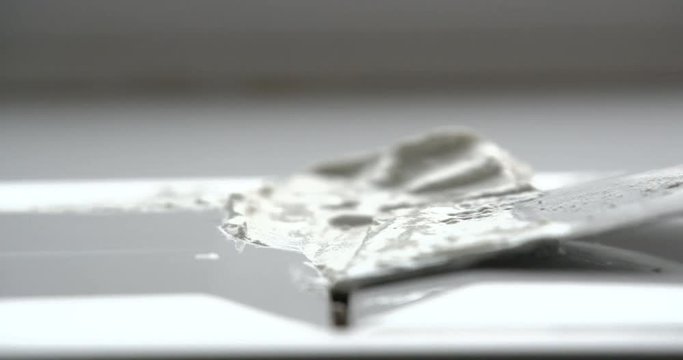 Adding grout to tiles with trowel