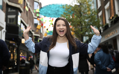 Beautiful Asian Woman Portrait Outdoors with Brown Hair Smiling With The Hands Up