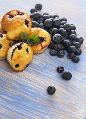 muffin with blueberries on a wooden table. fresh berries and sweet pastries on the board.