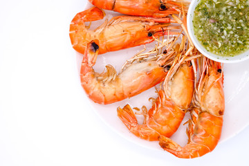 Top view and close up: Grilled shrimp on white dish and spicy seafood sauce (Thai style food) in bowl isolated on white background.