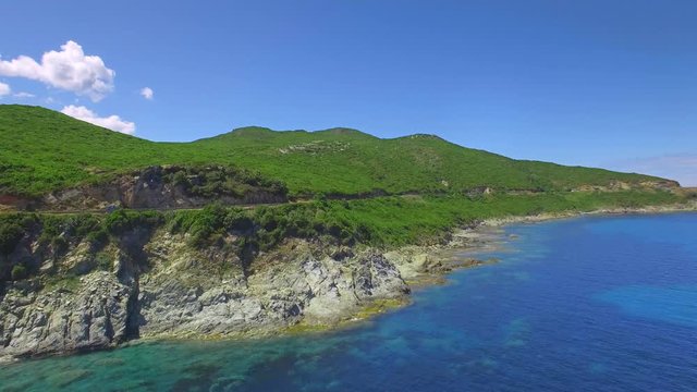 4K Cinematic adventure shot - aerial panorama of an island. Flying along a beautiful coast - crips water and blue sky. Amazing nature drone shot