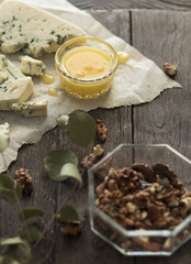 cheese, honey and nuts on a wooden board