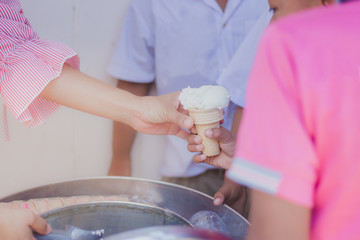 Close-up to Teacher 's hands.Give ice cream to students.