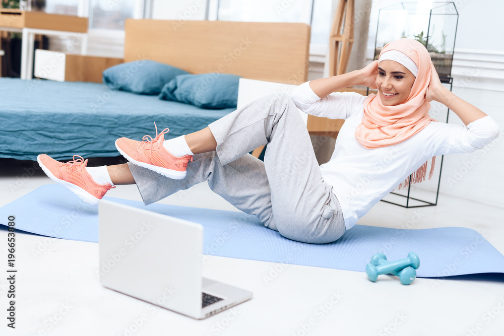 Wall mural Arab woman doing gymnastics in the bedroom.