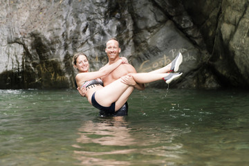 Fototapeta premium Attractive couple under jungle waterfall