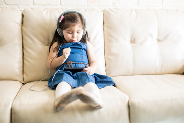Cute girl watching her favorite movie on cell phone