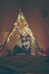 Mother and daughter taking selfie in a teepee © Impact Photography