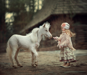 a little girl with a mini horse