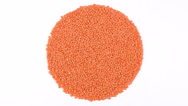 Healthy raw organic red lentils closeup. Vegetarian food rotate isolated on white background.