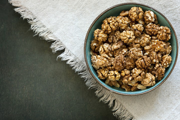 Close-up of a bowl with walnuts on a vintage wooden background. Top view, background.
