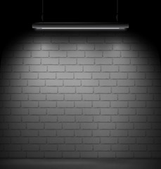 Dark room with a brick wall on the background and fluorescent lamp light.