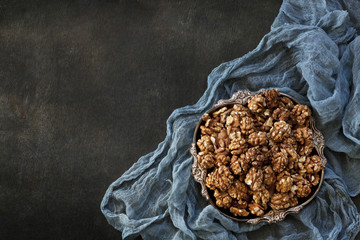 Close-up of a bowl with walnuts on a vintage wooden background. Top view, background. - Powered by Adobe