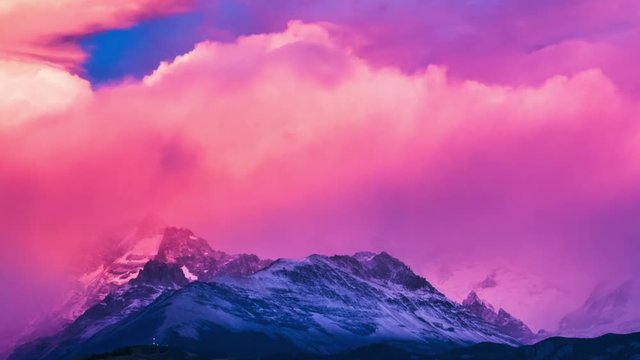 Sunrise over the Fitz Roy mountain covered with clouds. Zoom out timelapse of a fluffy clouds running in mountains. Patagonia, Argentina