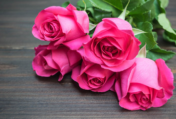 Pink rose on wooden background
