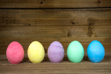 row of colorful Easter eggs on wood