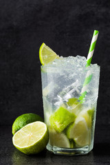 Caipirinha cocktail in glass on black stone