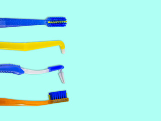 Special toothbrushes for care of braces (bracket systems), in a row, isolated on a light blue background, top view, with space for text