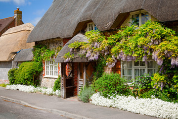Fototapeta na wymiar Traditional english thatched house with flower decoration in Southern England UK