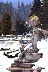 Sculpture from the 19th century on the background of the Carpathians in Sinai, Romania. In the winter.