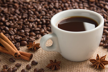 Obraz na płótnie Canvas cup of hot espresso on beige cloth sackcloth with coffee beans