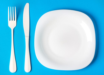 plate fork knife cutlery white blue background concept menu restaurant cafe kitchen
