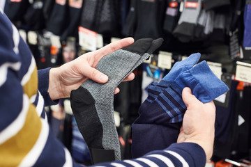 Male buyer chooses socks in the store