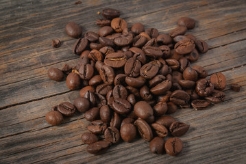 Spilled grains of roasted coffee on old raw boards