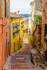 Colorful street with traditional buildings in the old town of Menton, Provence region, France