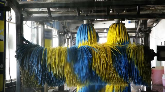 Inside view of equipment of automatic car wash with colored brushes