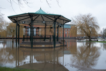 flooded town centre with bandstand completely surrounded by brown flood water from the river Avon