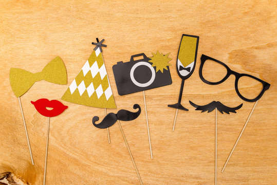 Colorful party decoration used for funny photographs on wooden background from above