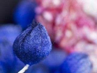 Blue buds and pink lilacs on a black background. Artificial flowers