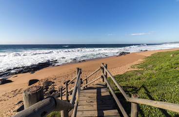 Leerer Holzsteg, der zum Strand in Südafrika führt