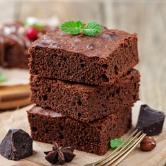 Chocolate brownie cake, dessert with nuts on wooden background.